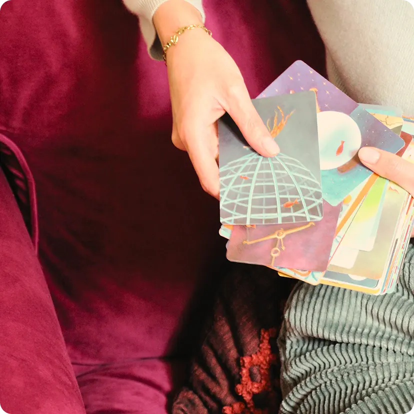 Mani che tengono un mazzo di carte illustrate utilizzate nei percorsi per famiglie, dettaglio delle attività di supporto relazionale