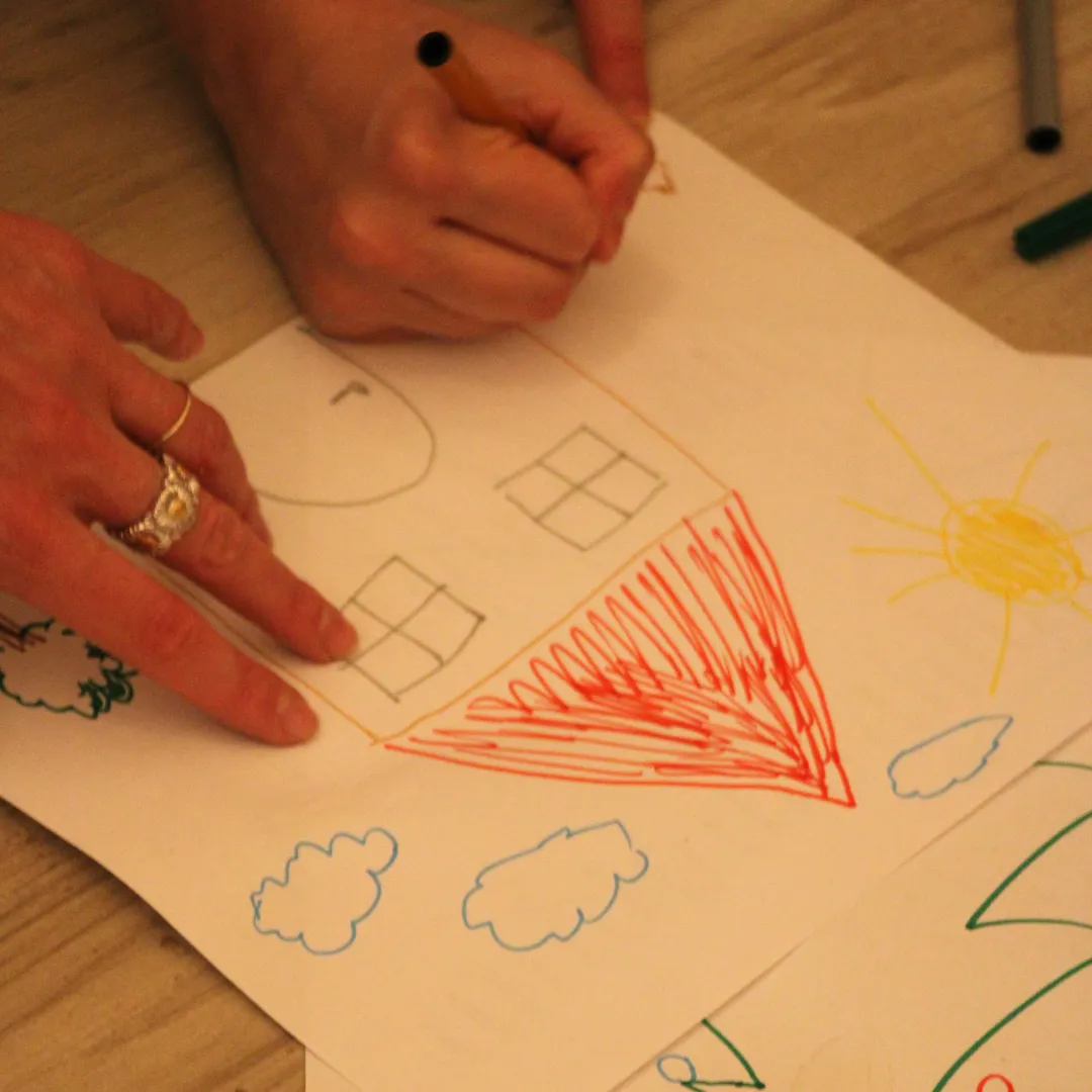 Tazza colorata con pennarelli e carte illustrate nello spazio dedicato ai bambini, strumenti per attività creative e percorsi di sviluppo emotivo.
